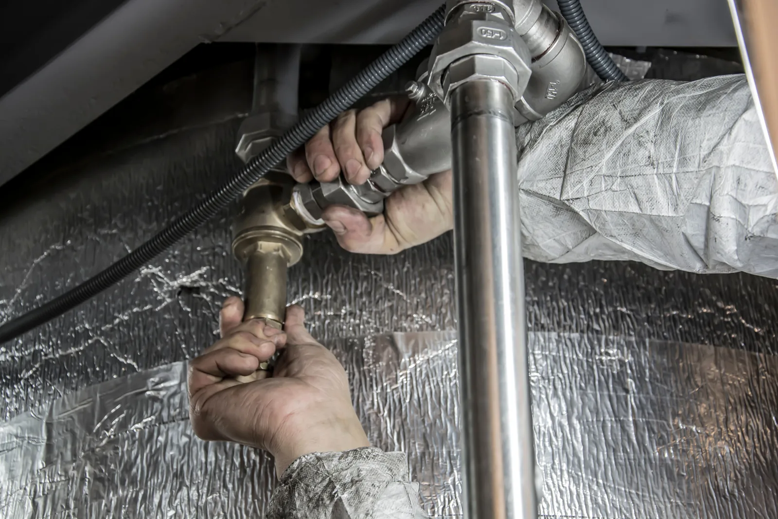 Plumber repairing frozen pipe damage in a Boston home